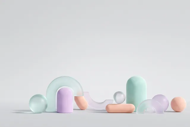 Frosted glass arches, spheres and matte pastel pills on a light grey studio floor. Clean product-shot light.